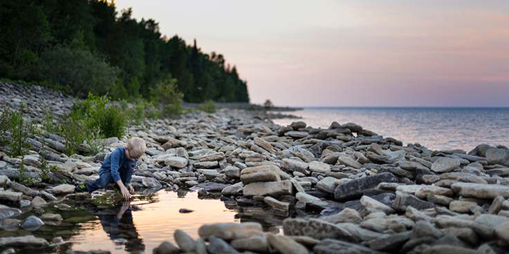 boy playing in water at lake edge